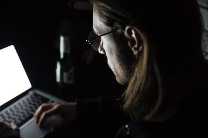 Concentrated man using laptop computer at home indoors